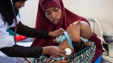 Image: A health worker examines a girl.